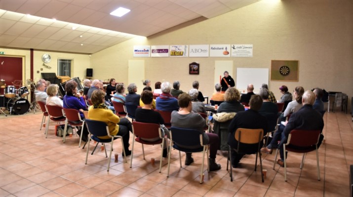 groep zittend in multifunctionele accommodatie en luisterend naar spreker